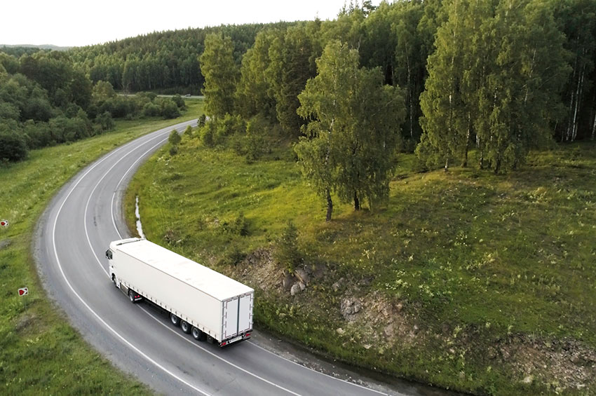 Aerial view of a semi-truck on a winding road concept image, representing FMCSA cargo securement rules and liability after a Georgia truck crash